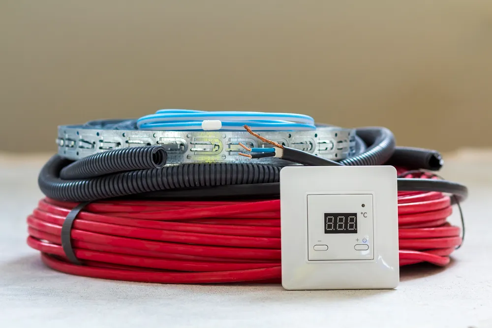 Rollos de cable y tubería con un termostato digital, ilustrando las Ventajas controlador de temperatura